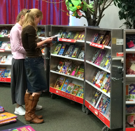 Staff members look at books at the Scholastic Book Fair