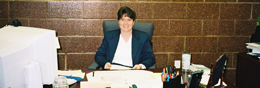 Staff member poses at her desk